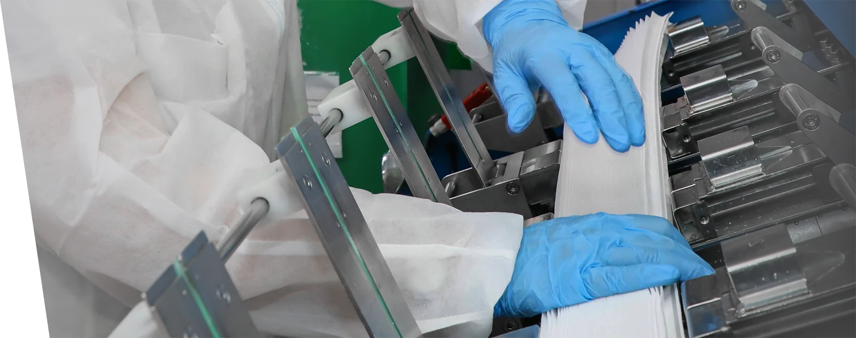 An employee is using equipment to produce pleated filter cartridges
