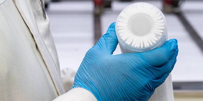Researchers holding a folded filter core